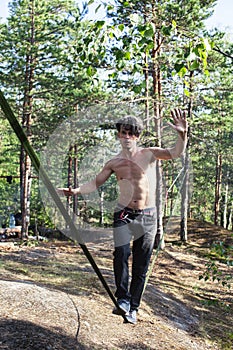 Young man doing slackline rodeo in forrest outside sports activities, lifestyle people concept