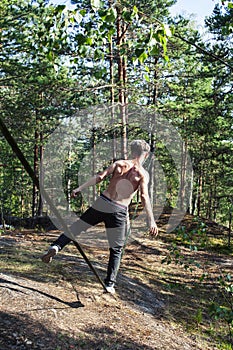 Young man doing slackline rodeo in forrest outside sports activities, lifestyle people concept