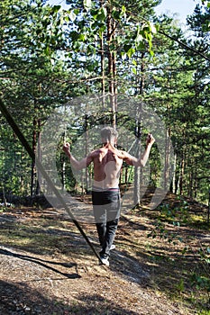 Young man doing slackline rodeo in forrest outside sports activities, lifestyle people concept