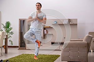 Young man doing sport exercises at home