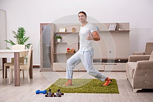 Young man doing sport exercises at home