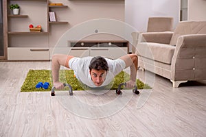 Young man doing sport exercises at home