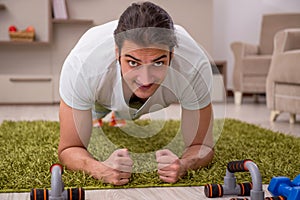 Young man doing sport exercises at home