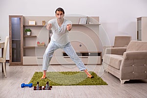 Young man doing sport exercises at home