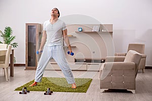 Young man doing sport exercises at home