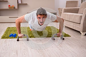 Young man doing sport exercises at home