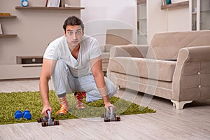 Young man doing sport exercises at home