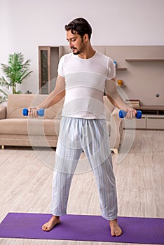 Young man doing sport exercises at home