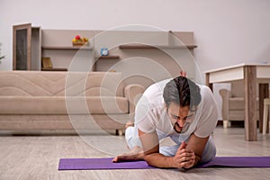 Young man doing sport exercises at home