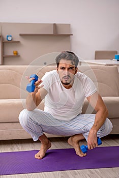 Young man doing sport exercises at home