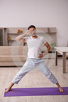 Young man doing sport exercises at home