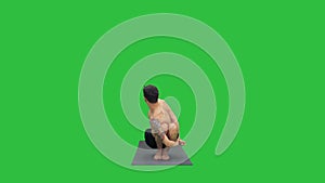 Young man doing squat with twist and bend yoga on a Green Screen, Chroma Key.