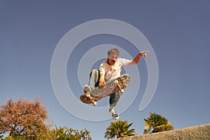 A young man doing tricks in the air on his skateboard at the skate park. Active sport concept