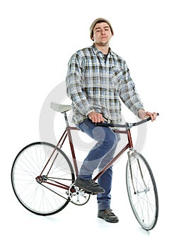 Young man doing tricks on fixed gear bicycle on a white