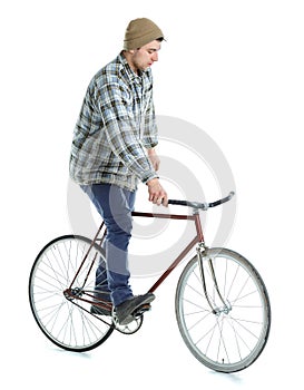 Young man doing tricks on fixed gear bicycle on a white