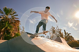 A young man doing tricks on his skateboard at the skate park. Active sport concept