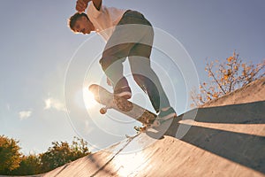 A young man doing tricks on his skateboard at the skate park. Active sport concept