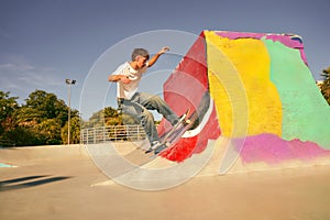 A young man doing tricks on his skateboard at the skate park. Active sport concept