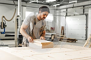 Young man doing woodwork in carpentry factory close up