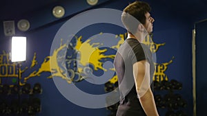 Young man doing workout. Man makes circular turns head and stretching neck