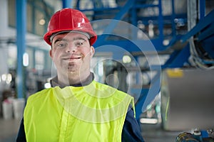 Young man with Down syndrome working in industrial factory, social integration concept.