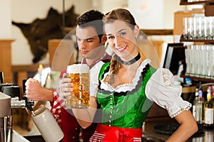 Young man drawing beer in restaurant or pub