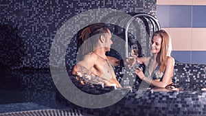 Young man with dreadlocks and beautiful woman relaxing in the pool