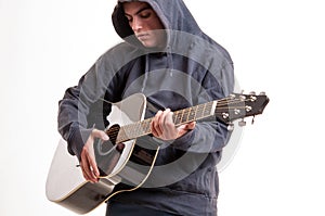 Young man dressed in hoodie try to understand how to play acous