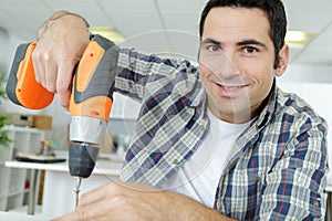 young man drilling hole with impact drill