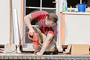 A young man drilling a hole