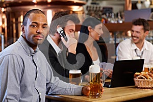 Young man drinking beer in pub