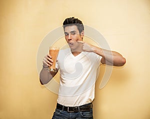 Young man drinking big glass of healthy fruit