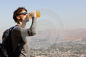 Young man drinking bottle of water outdoors