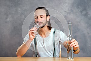 Young man drinking clear spirit