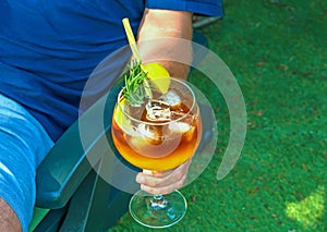 Young man drinking cocktail at home in the garden.