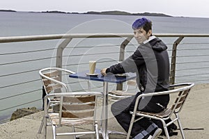 Young man drinking cofee at seaside