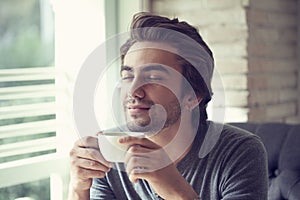 Young man drinking coffee in cafe