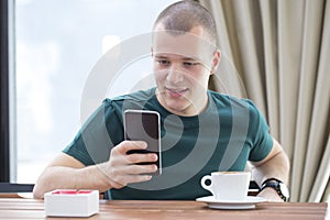 Young man drinking coffee and chat with their friends via mobile