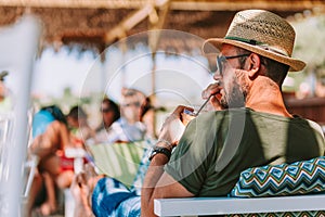 Young man drinking ice coffee in a beach bar