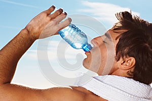Young man, drinking water bottle or towel for workout with health body, fitness and vacation. Model, thirsty or natural