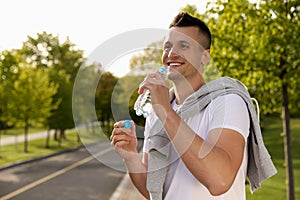 Young man drinking water. Morning fitness