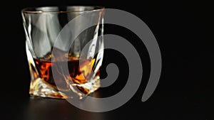 Young man drinking whiskey over black background