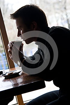 Giovane uomo bevande caffè un ristorante 