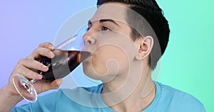 Young man drinks a drink with ice. The guy quenches his thirst