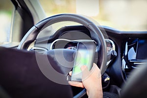 Young man driver using mobile phone in car, hand holding smart phone and driving and texting, transport business concept