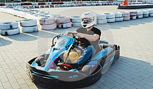 A young man drives a go kart at circuit