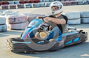 A young man drives a go kart at circuit