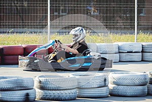 A young man drives a go kart at circuit