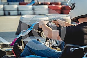 A young man drives a go kart at circuit