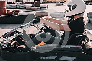 A young man drives a go kart at circuit